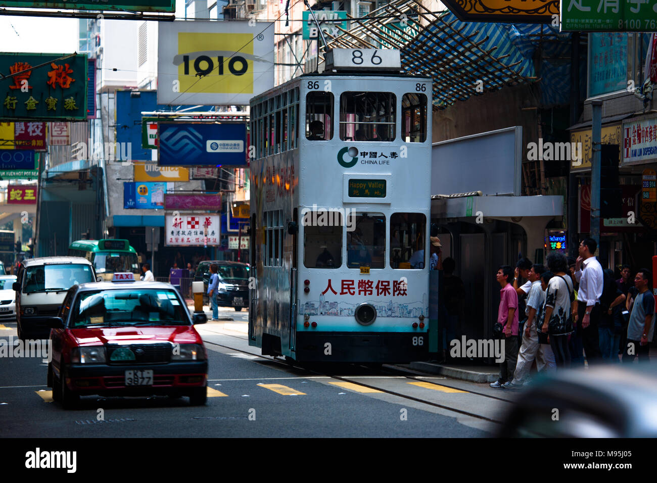Un iconico double-decker bus tram viaggiano in una strada trafficata nel centro cittadino di Hong Kong, Cina Foto Stock