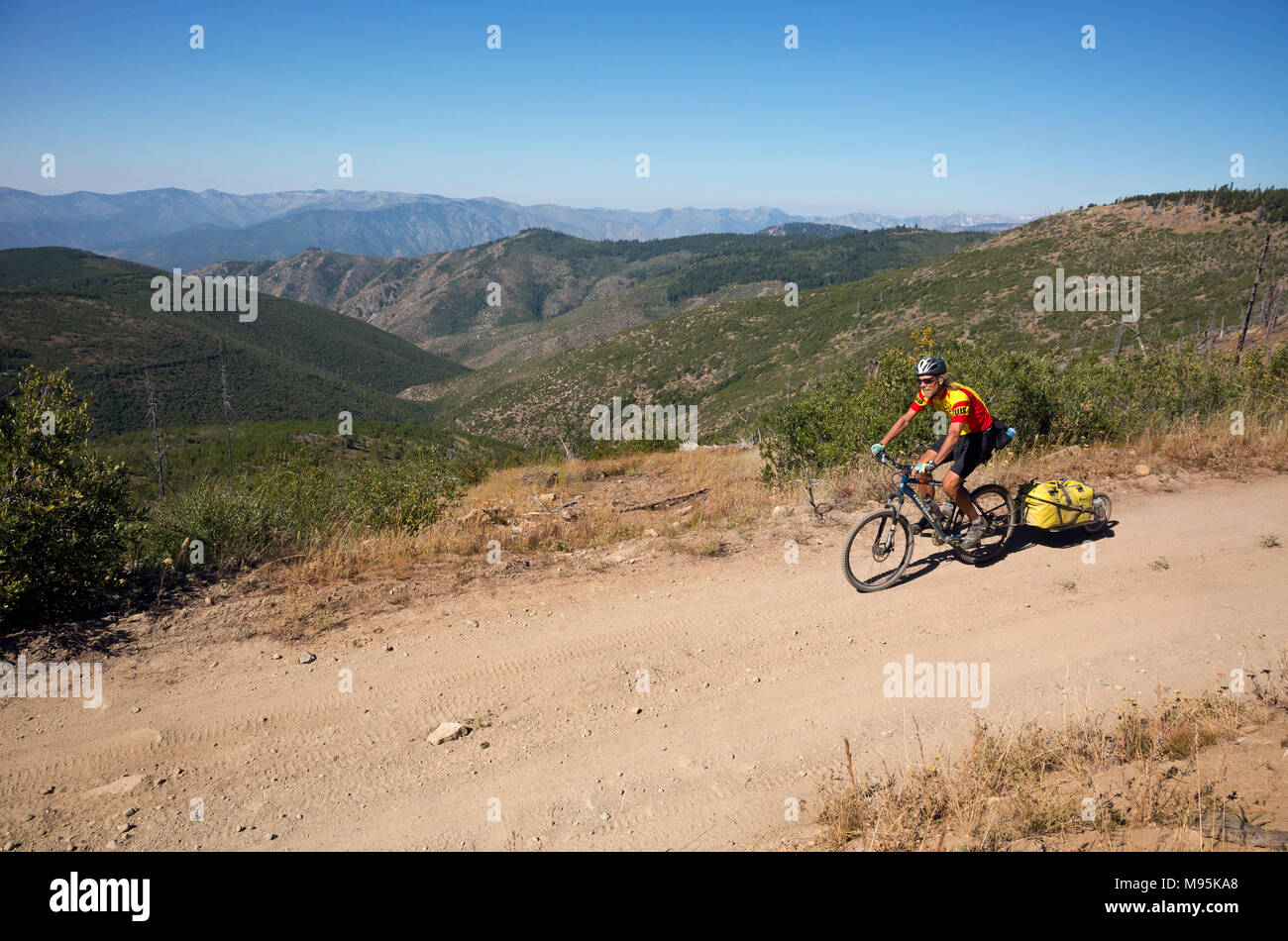 WA13919-00...WASHINGTON - Tom Kirkendall equitazione sui monti Chelan mentre si segue il moto di Butler Washington Backcountry Percorso paesaggistico. Foto Stock