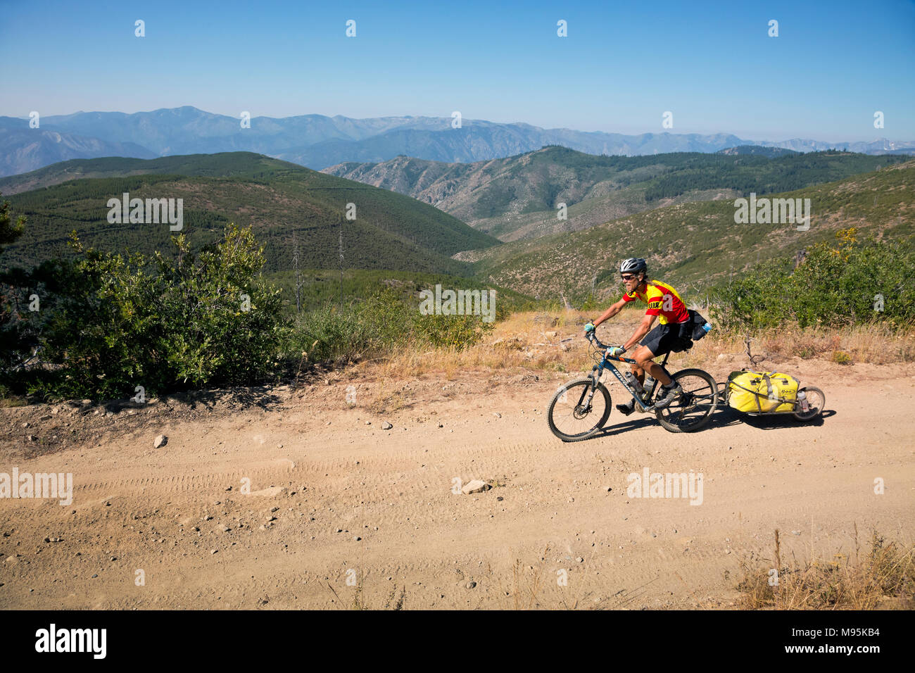 WA13920-00...WASHINGTON - Tom Kirkendall equitazione sui monti Chelan mentre si segue il moto di Butler Washington Backcountry Percorso paesaggistico. Foto Stock