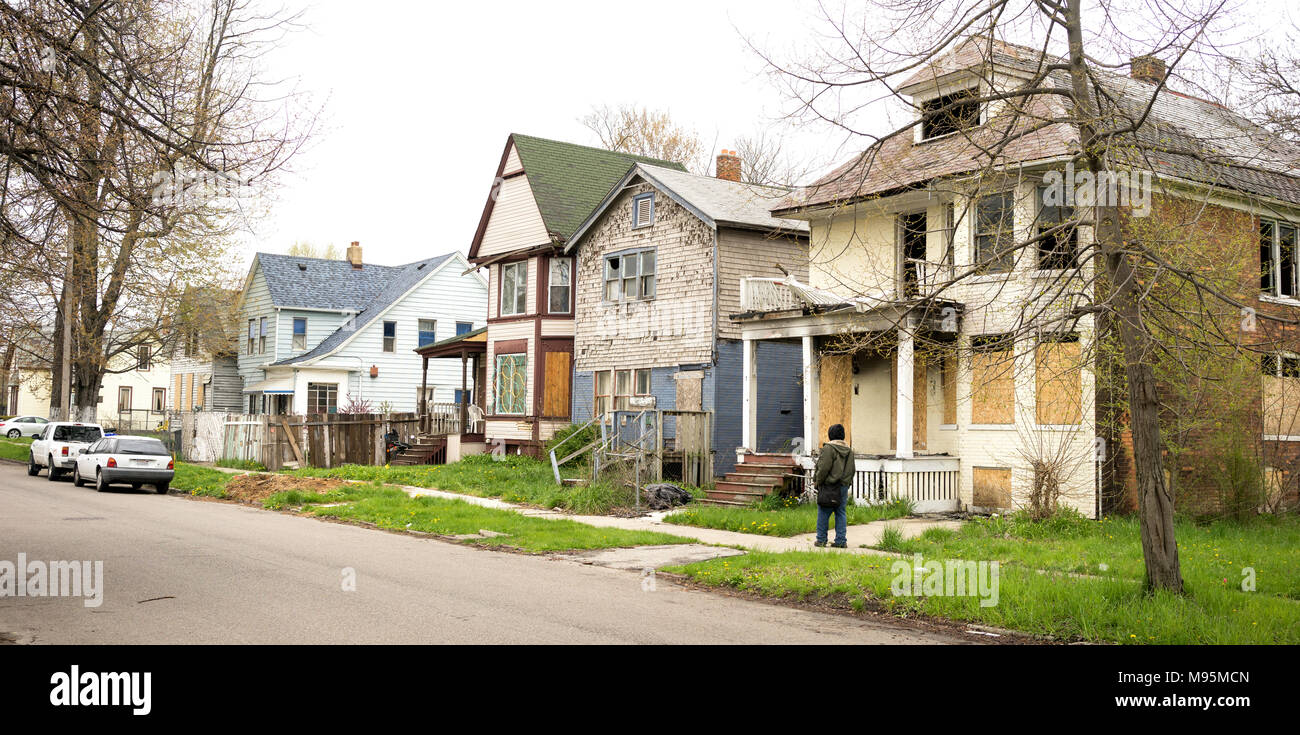 Detroit Michigan intavolato case abbandonate a dominare il paesaggio persona camminare per la strada Foto Stock