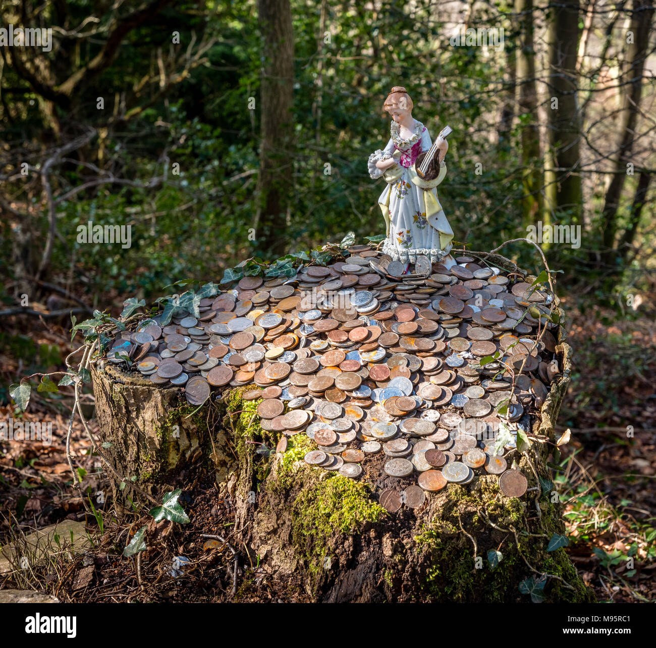 Fairy in ceramica e monete lasciate come buona fortuna gettoni su un ceppo di albero in prossimità del diavolo pulpito sopra la valle di Wye in Monmouthshire REGNO UNITO Foto Stock