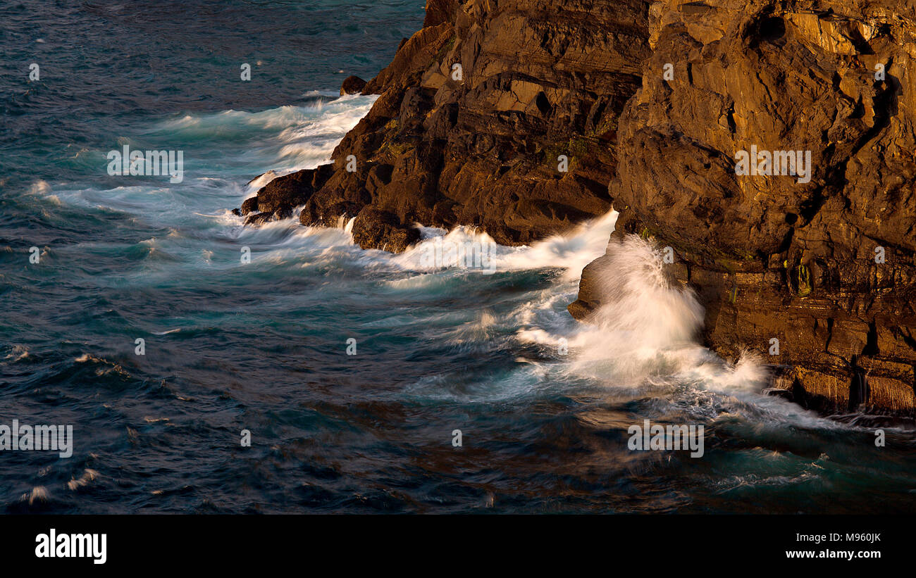 Onde che si infrangono contro le rocce in testa ad anello su Irlanda dalla costa atlantica della contea di Clare Foto Stock