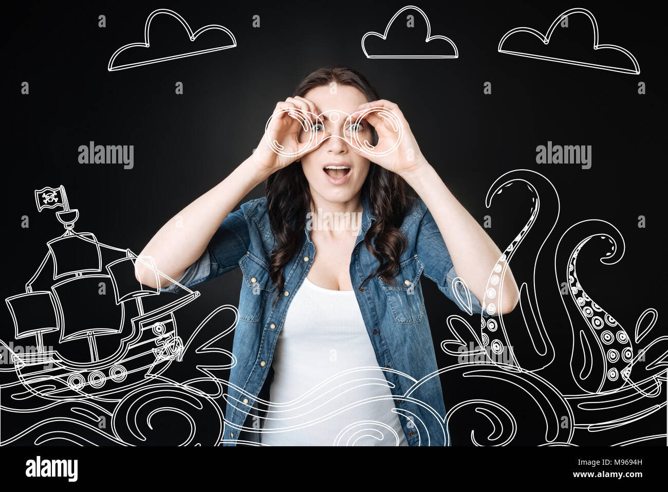 Donna emotiva tenendo un binocolo e guardando le navi Foto Stock