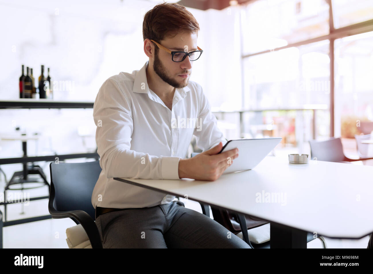 Fiducioso imprenditore occupato lavorando su tablet Foto Stock
