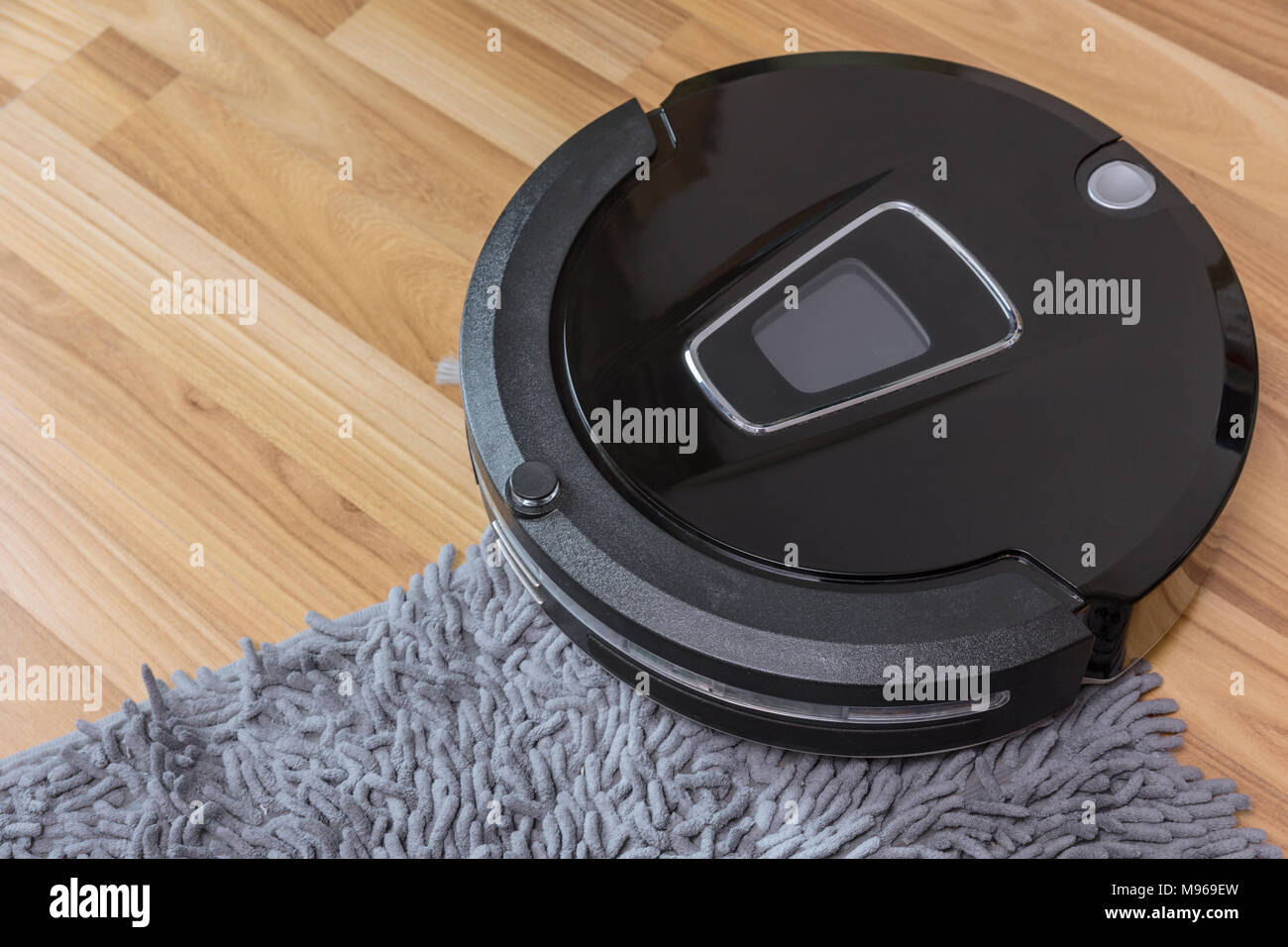 Robot aspirapolvere sul laminato pavimento in legno con pulizia moquette  Foto stock - Alamy