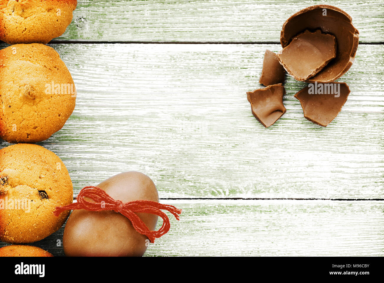 Uovo di cioccolato e muffin su un blu sullo sfondo di legno Foto Stock