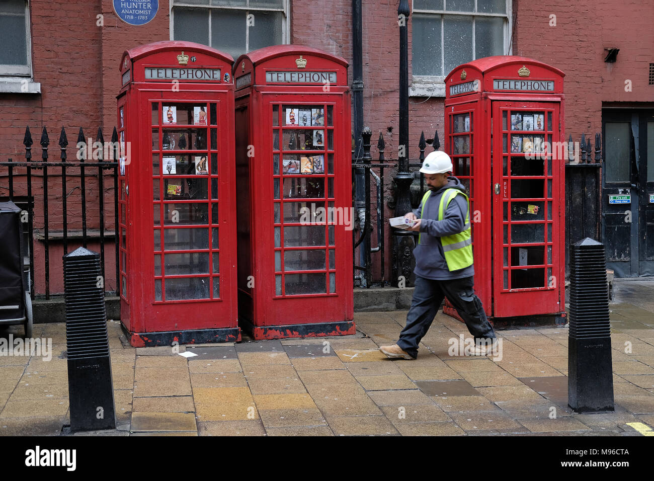 Lavoratore in un elmetto in London eating. Foto Stock