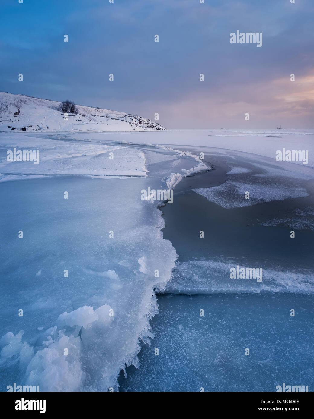 Scenic paesaggio invernale con il pupazzo di neve mare e tramonto in serata a Helsinki in Finlandia Foto Stock