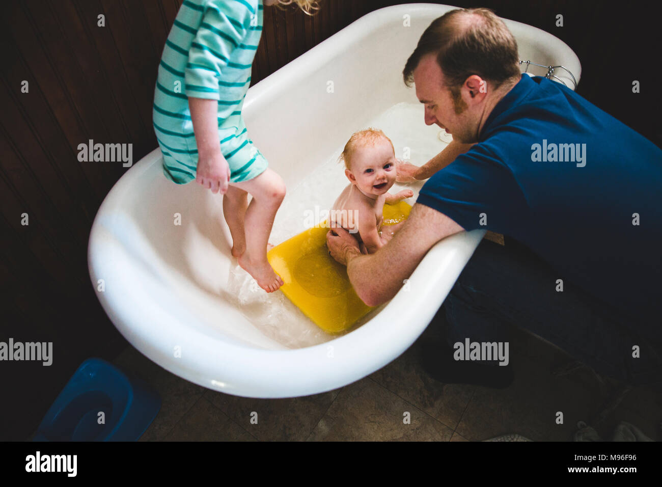 Il padre del bambino di lavaggio in vasca con altra ragazza Foto Stock