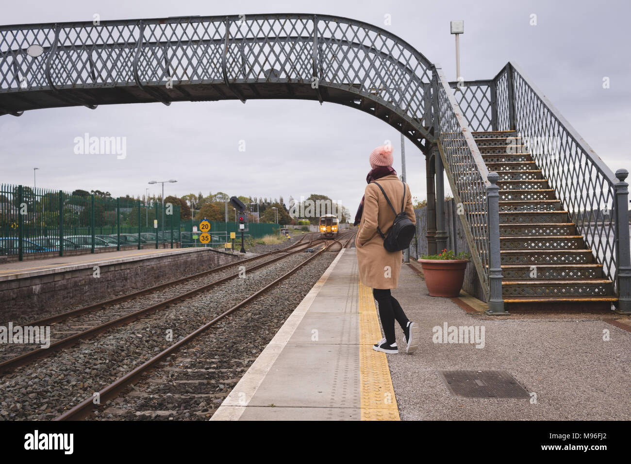 La donna in attesa del treno in stazione ferroviaria Foto Stock