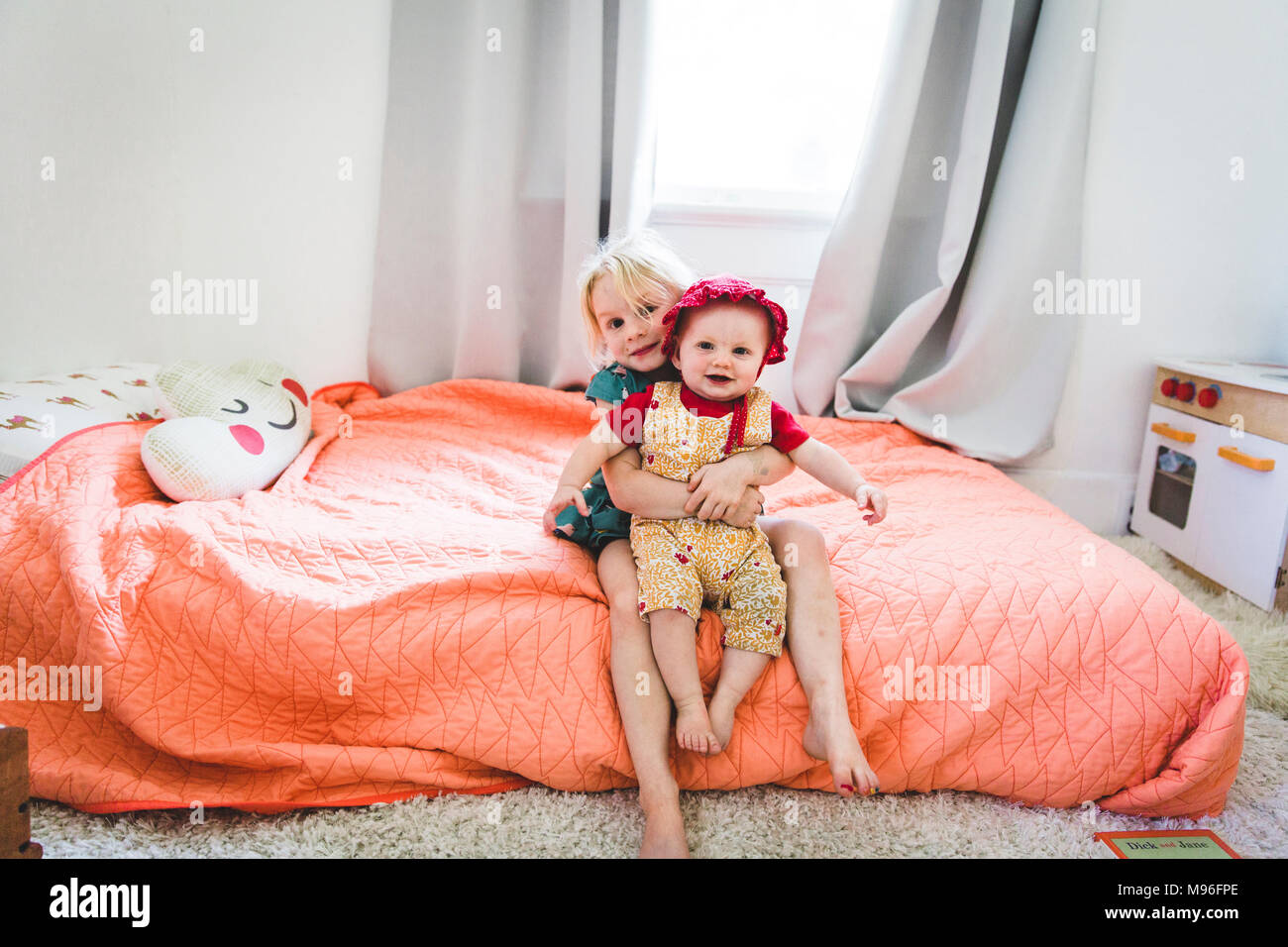 Ragazza con bambino sul letto Foto Stock