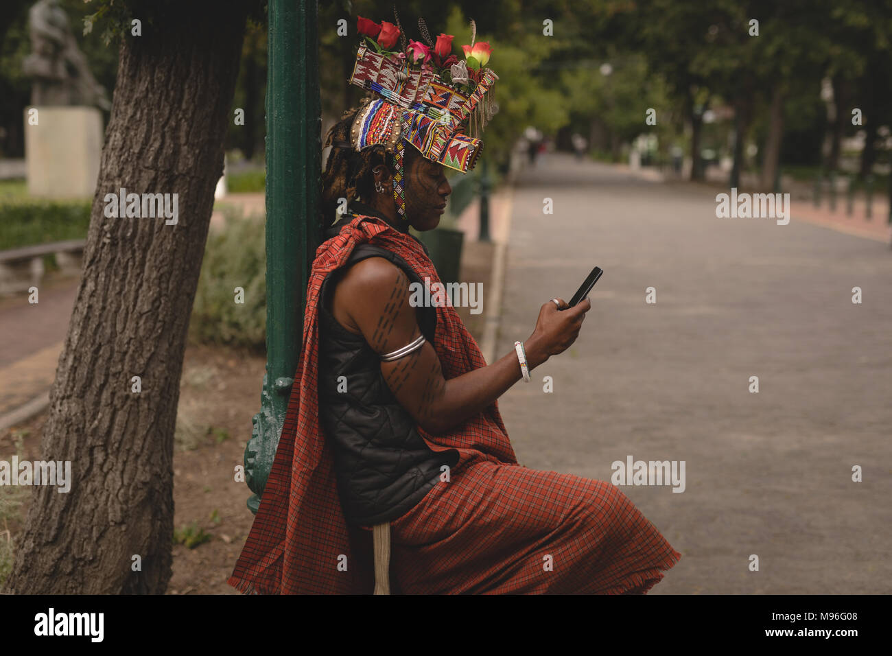 Maasai uomo in abbigliamento tradizionale utilizzando il telefono cellulare Foto Stock