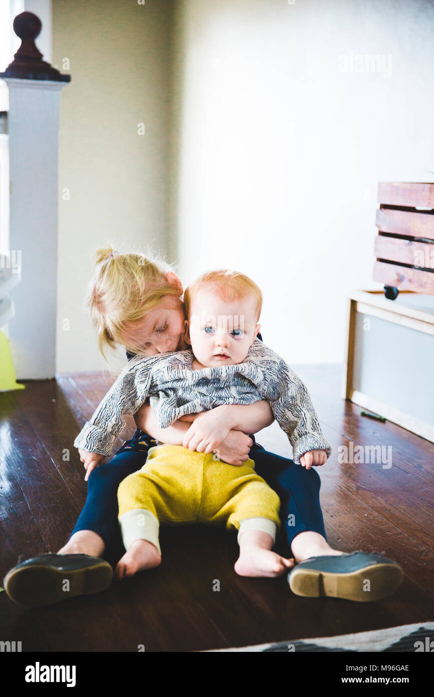 Baby sitter a ragazza in giro essendo abbracciato Foto Stock