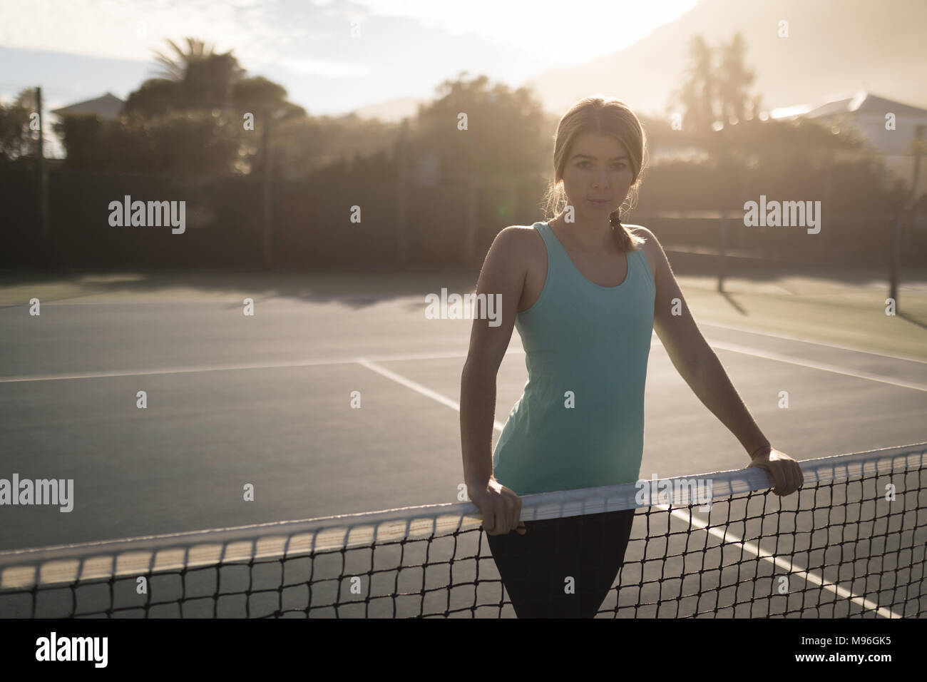 Donna in piedi nel campo da tennis Foto Stock