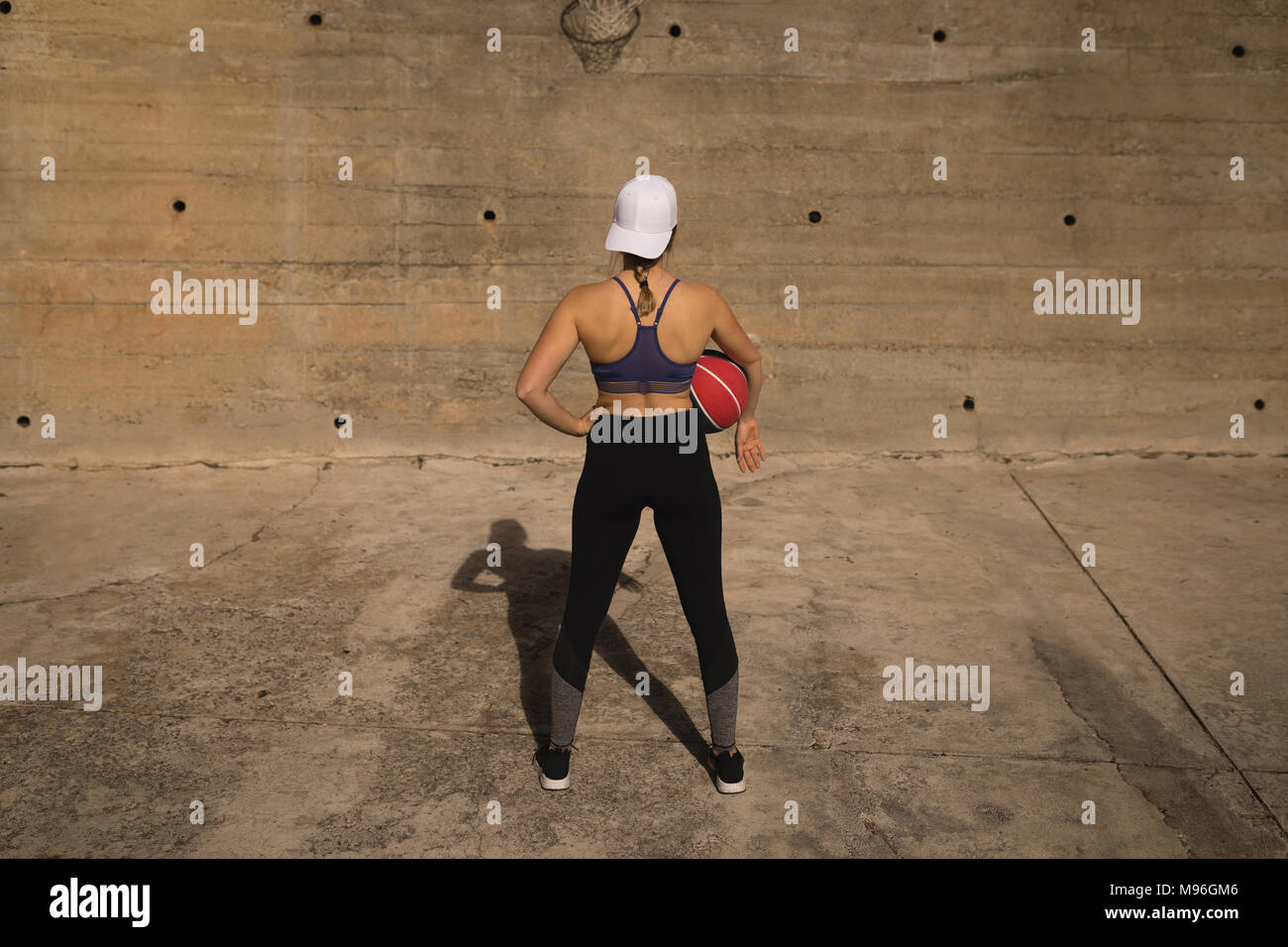 Donna che mantiene la pallacanestro nel campo di pallacanestro Foto Stock