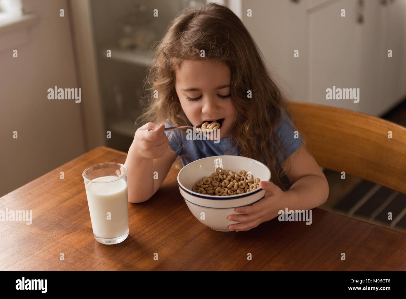 Ragazza di cereali per la prima colazione e il latte sul tavolo Foto Stock