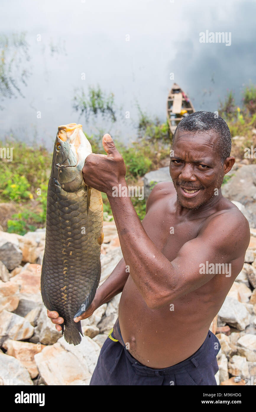 Kojo tenere la sua cattura sulla banca di Akosombo Dam, del Ghana meridionale. In Ghana, i bambini sono spesso dato un 'day' nome che corrisponde al giorno della settimana sono nati. Inoltre questi i nomi dei giorni hanno anche significati riguardanti l anima e il carattere di una persona. Per esempio, Kojo significa lunedì Nato e pace nel locale di lingua Akan. Foto Stock