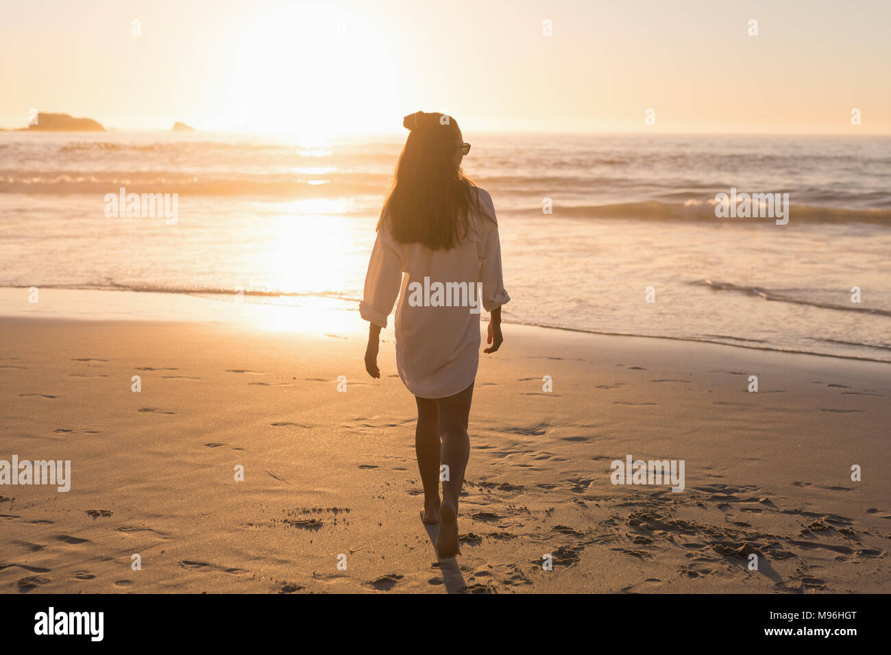 Donna che cammina in spiaggia Foto Stock