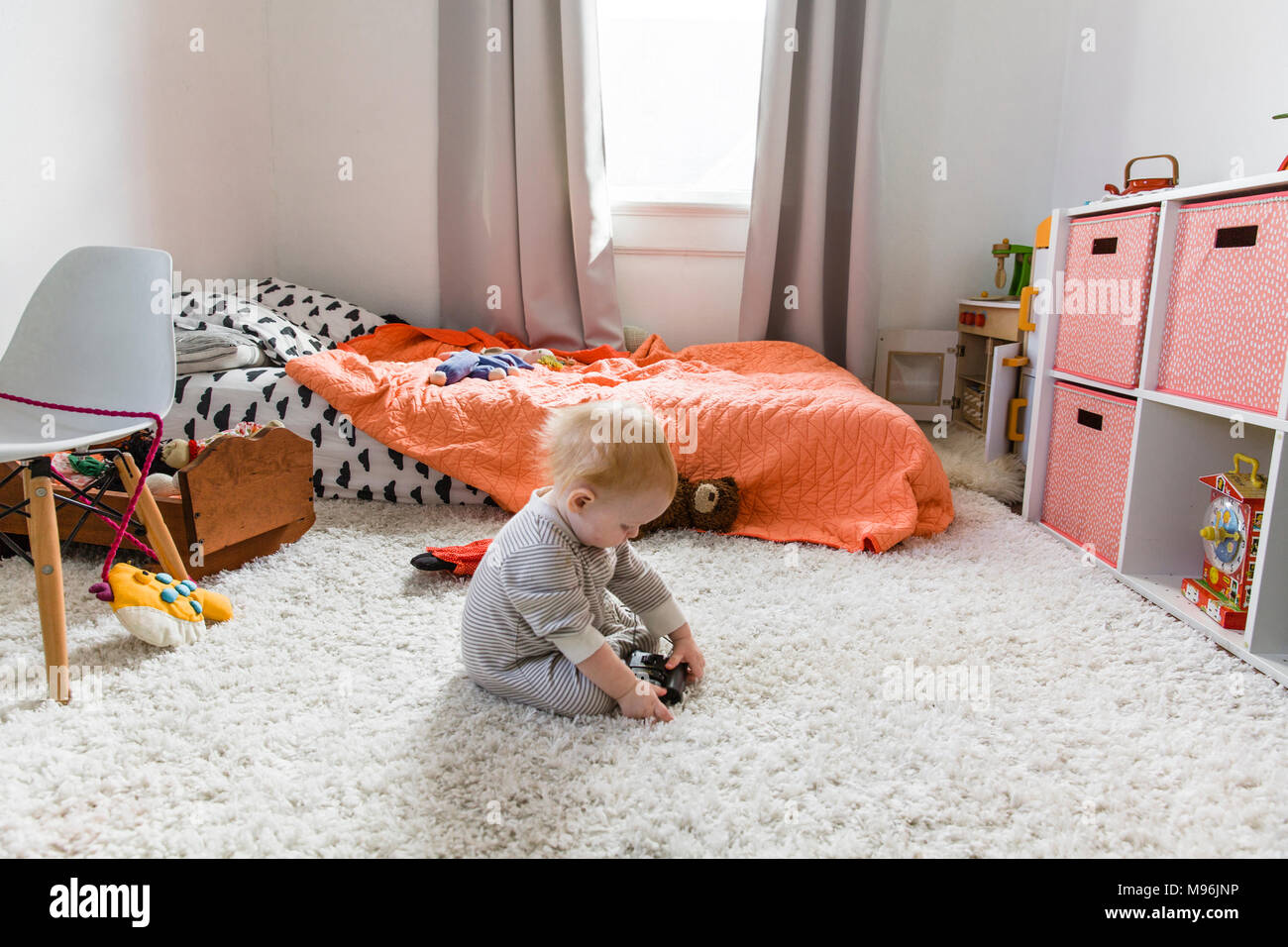 Baby giocando sul pavimento in camera da letto Foto Stock