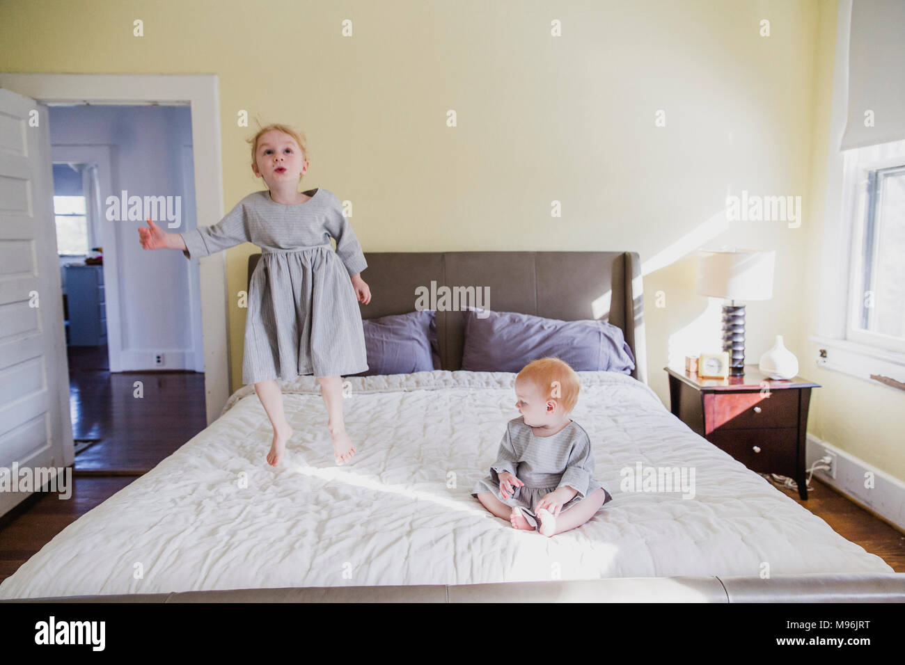 La ragazza e il bambino a giocare sul letto Foto Stock