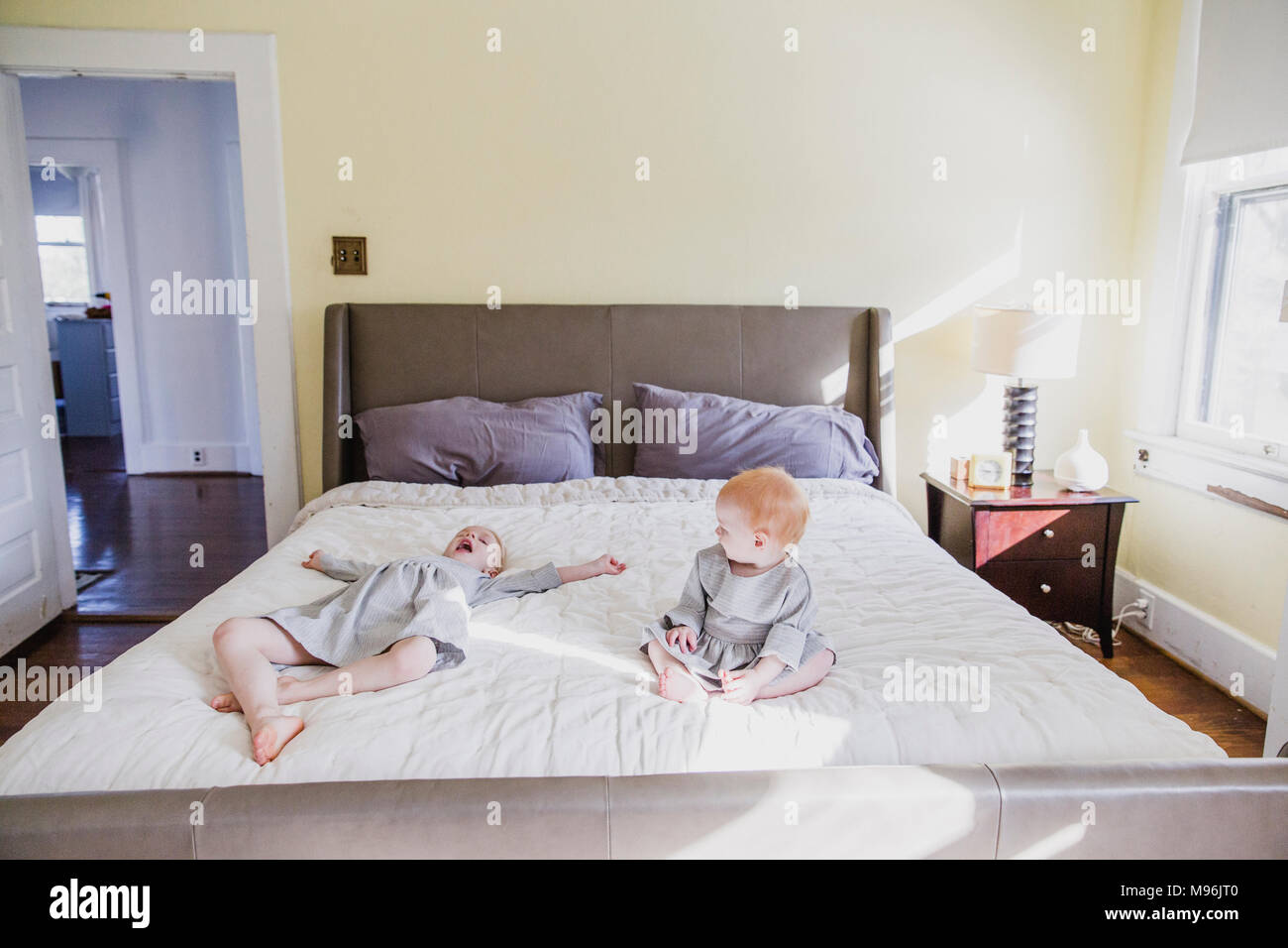 La ragazza e il bambino a giocare sul letto Foto Stock