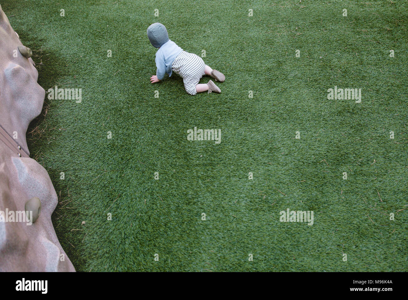 Il bambino gattona sull'erba Foto Stock