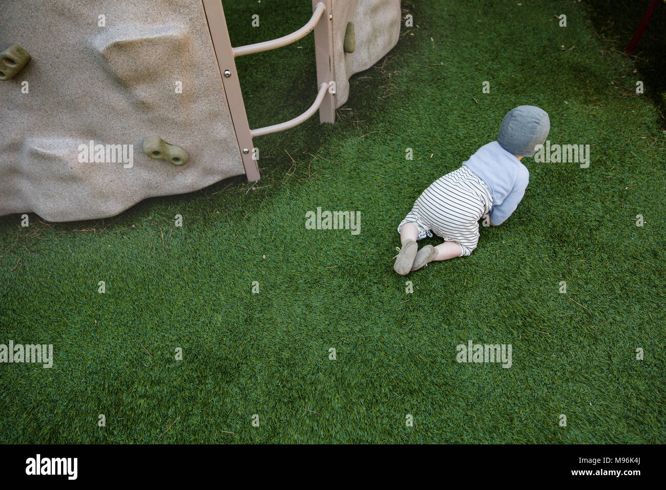 Il bambino gattona sull'erba Foto Stock