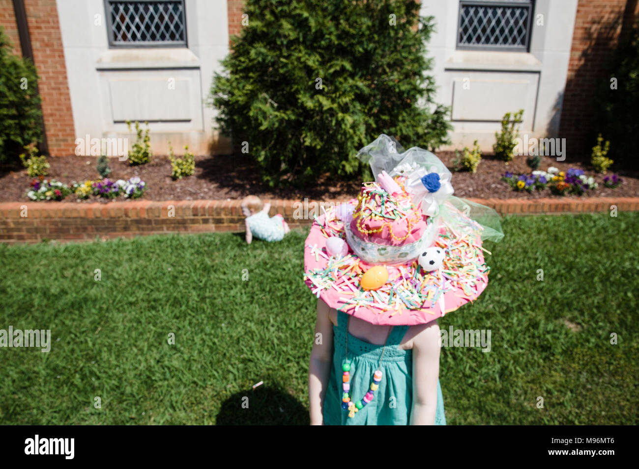 La ragazza con la Pasqua hat su avanti per baby Foto Stock