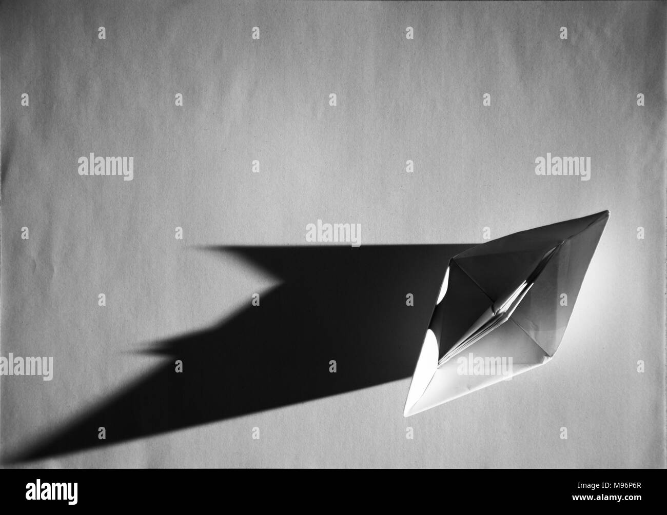 La barca di carta, origami, sta facendo le ombre taglienti in scala di grigi Foto stock - Alamy