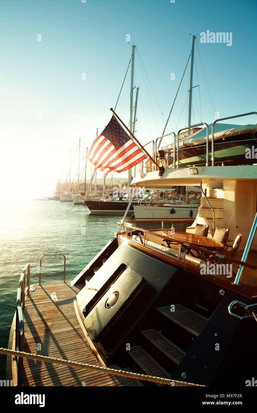 Bandiera degli Stati Uniti e yacht sul mare, inizio del viaggio americano Foto Stock