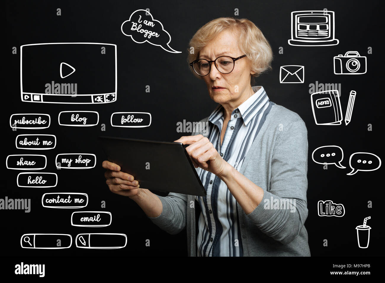 Titolare di pensione o di rendita grave rivolta verso lo schermo di un tablet mentre comunicare online Foto Stock