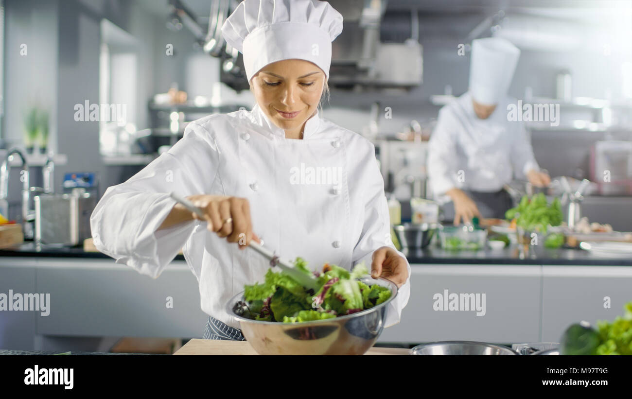 In un famoso ristorante cuoca prepara insalata. Lavora in una grande cucina moderna. Foto Stock