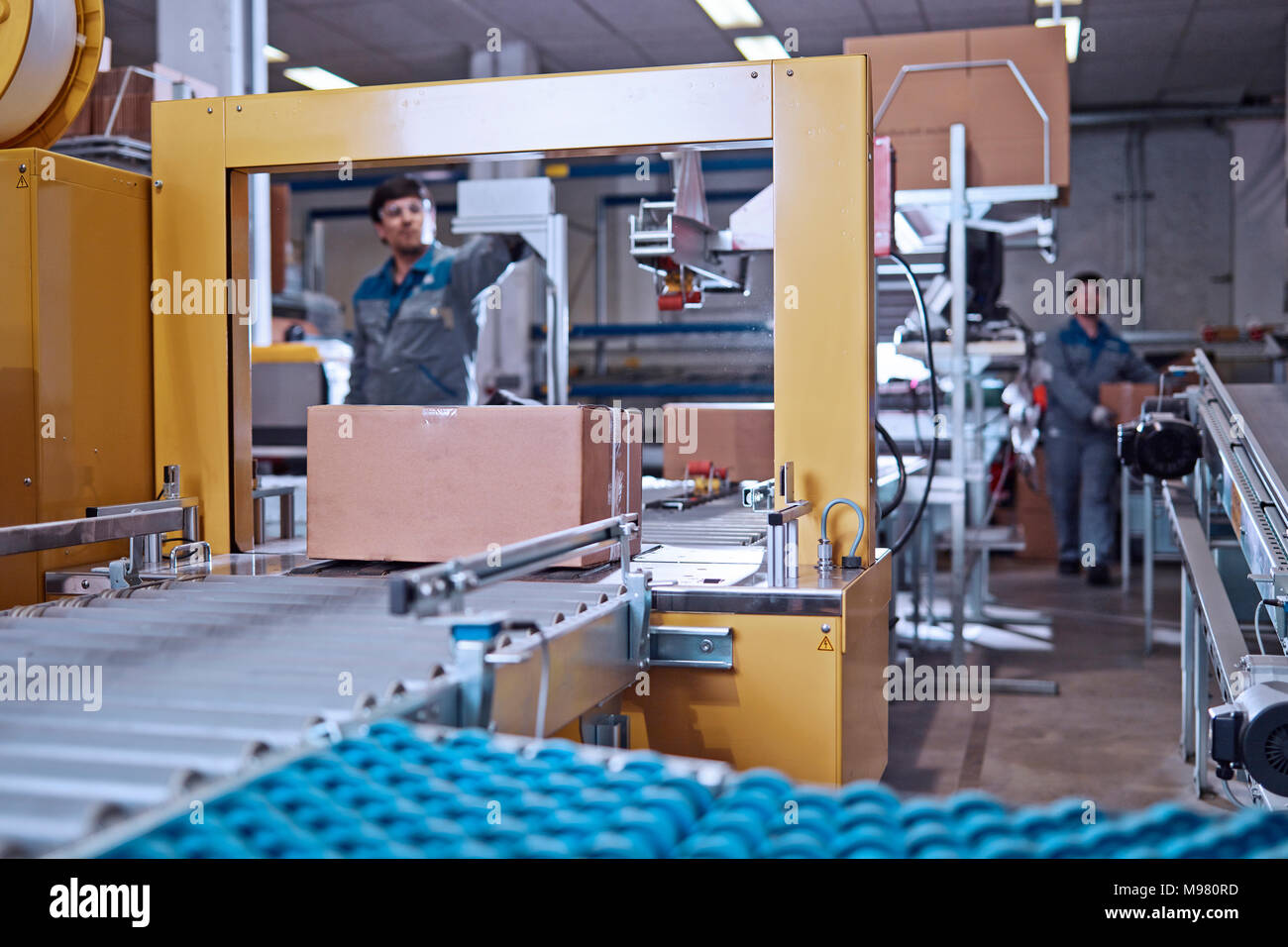 Gli uomini al lavoro al nastro trasportatore in fabbrica Foto Stock