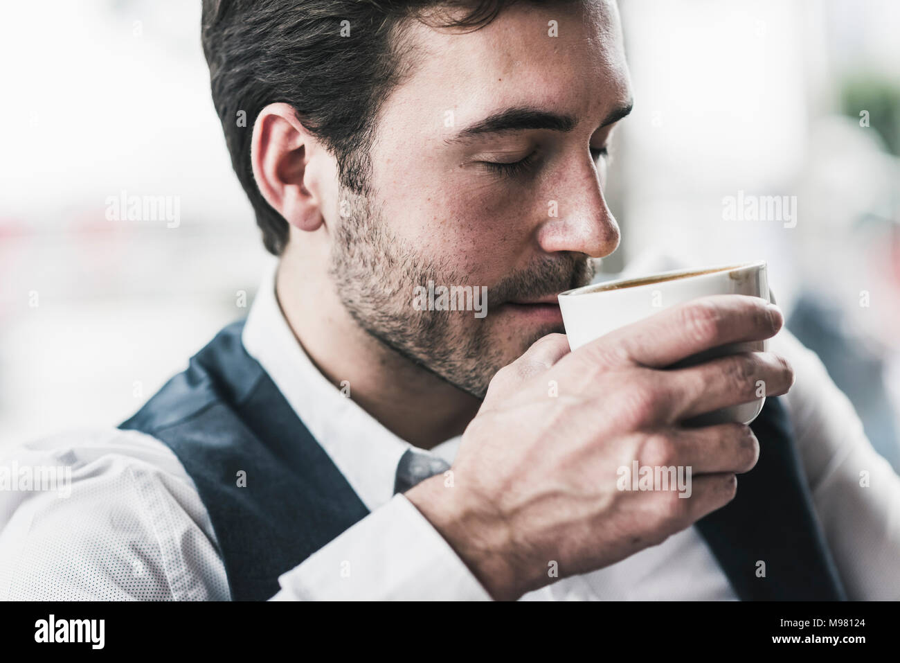 Rilassata giovane uomo bere tazza di caffè Foto Stock