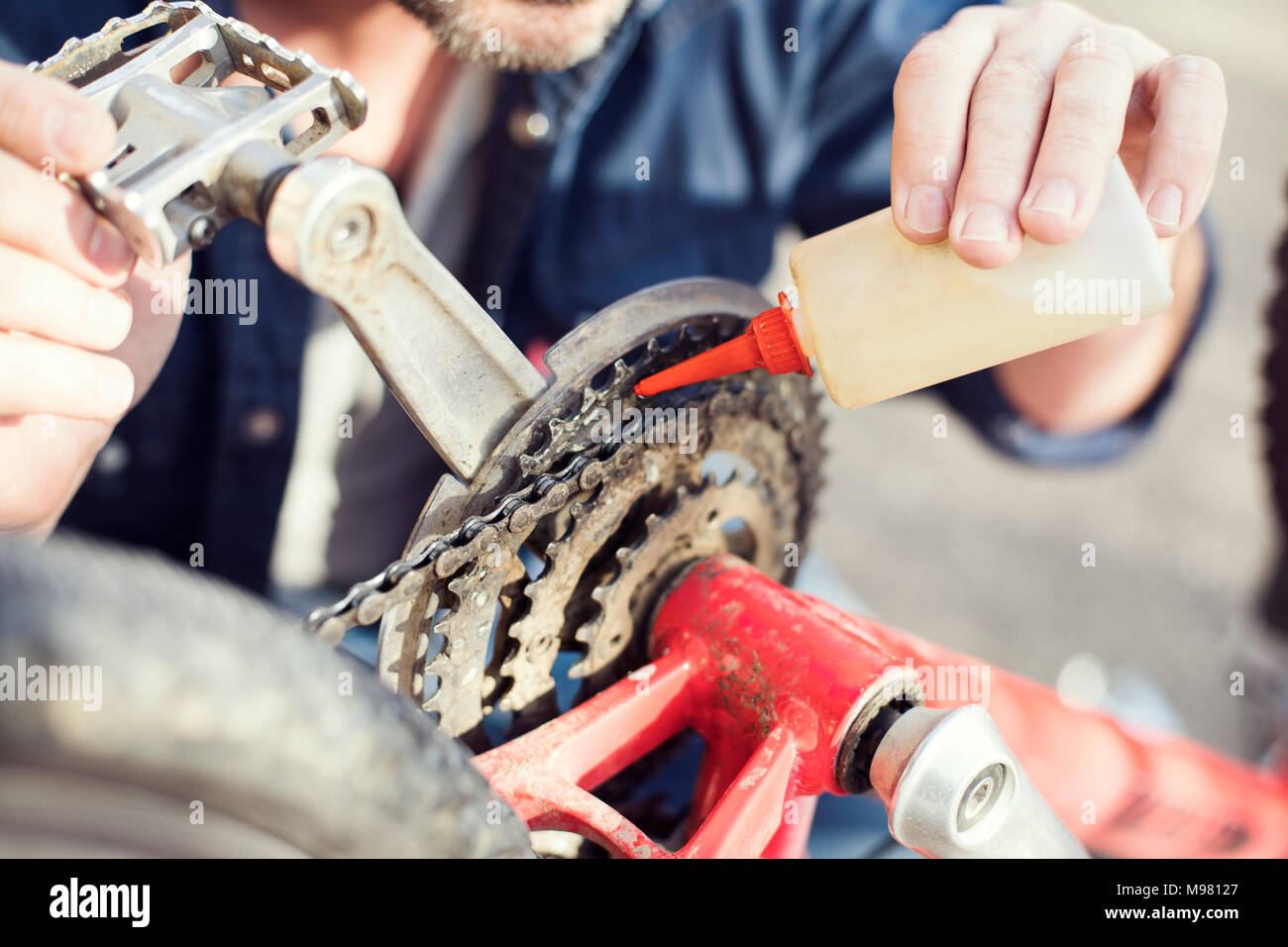 Uomo di lubrificazione della catena di bicicletta, close-up Foto Stock