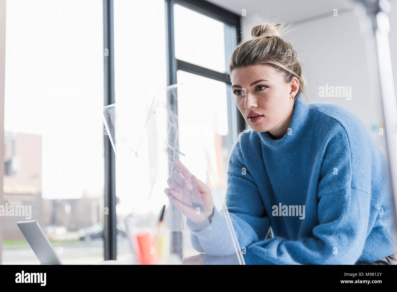 Giovane donna lavora sul design trasparente in office Foto Stock