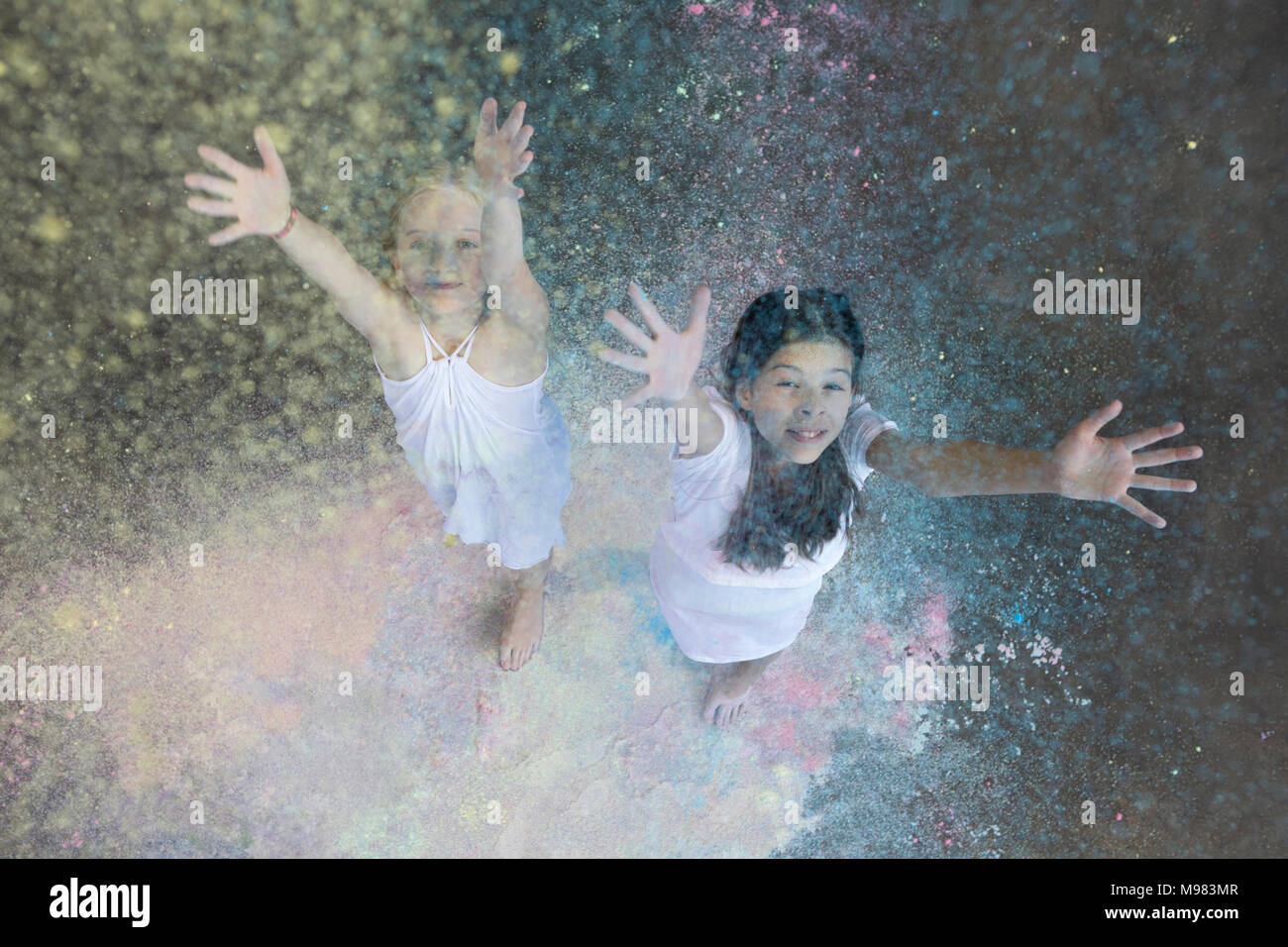 Ritratto di due amici di gettare polvere di colore in aria Foto Stock