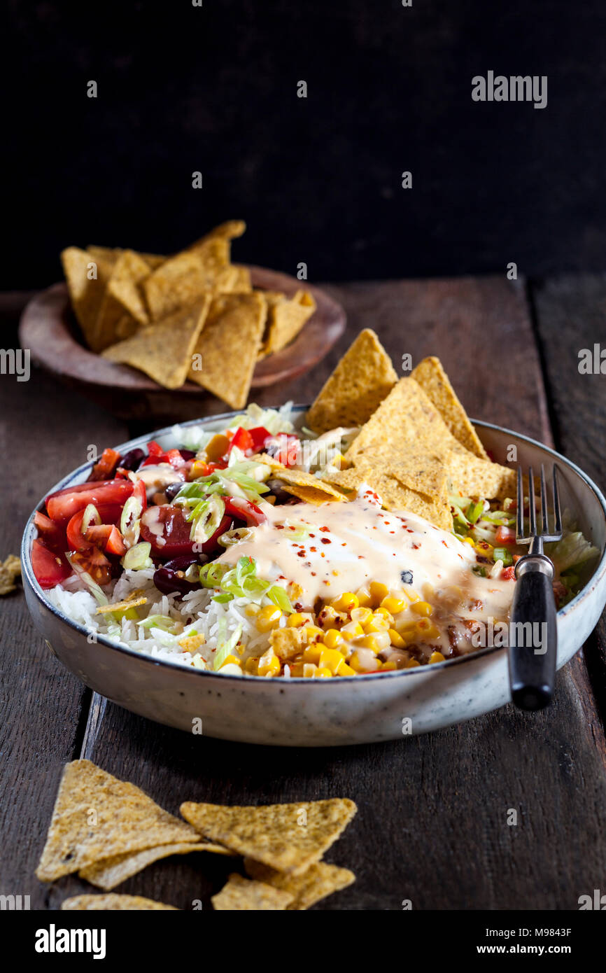 Taco insalatiera con riso, mais, chili con carne, i fagioli bianchi, lattuga iceberg, panna acida, nacho chips, pomodori Foto Stock