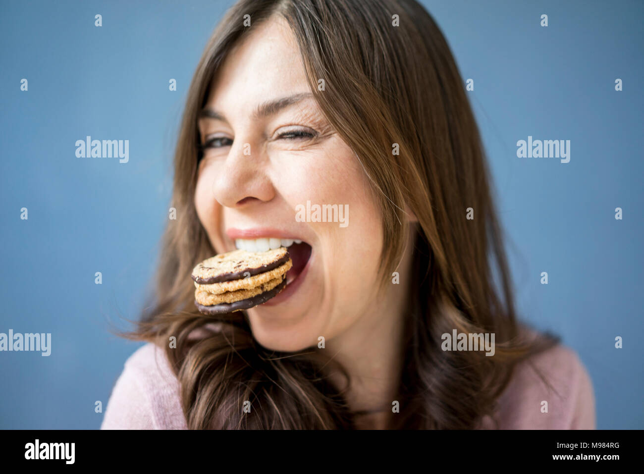 Ritratto di donna felice di mangiare una torta Foto Stock