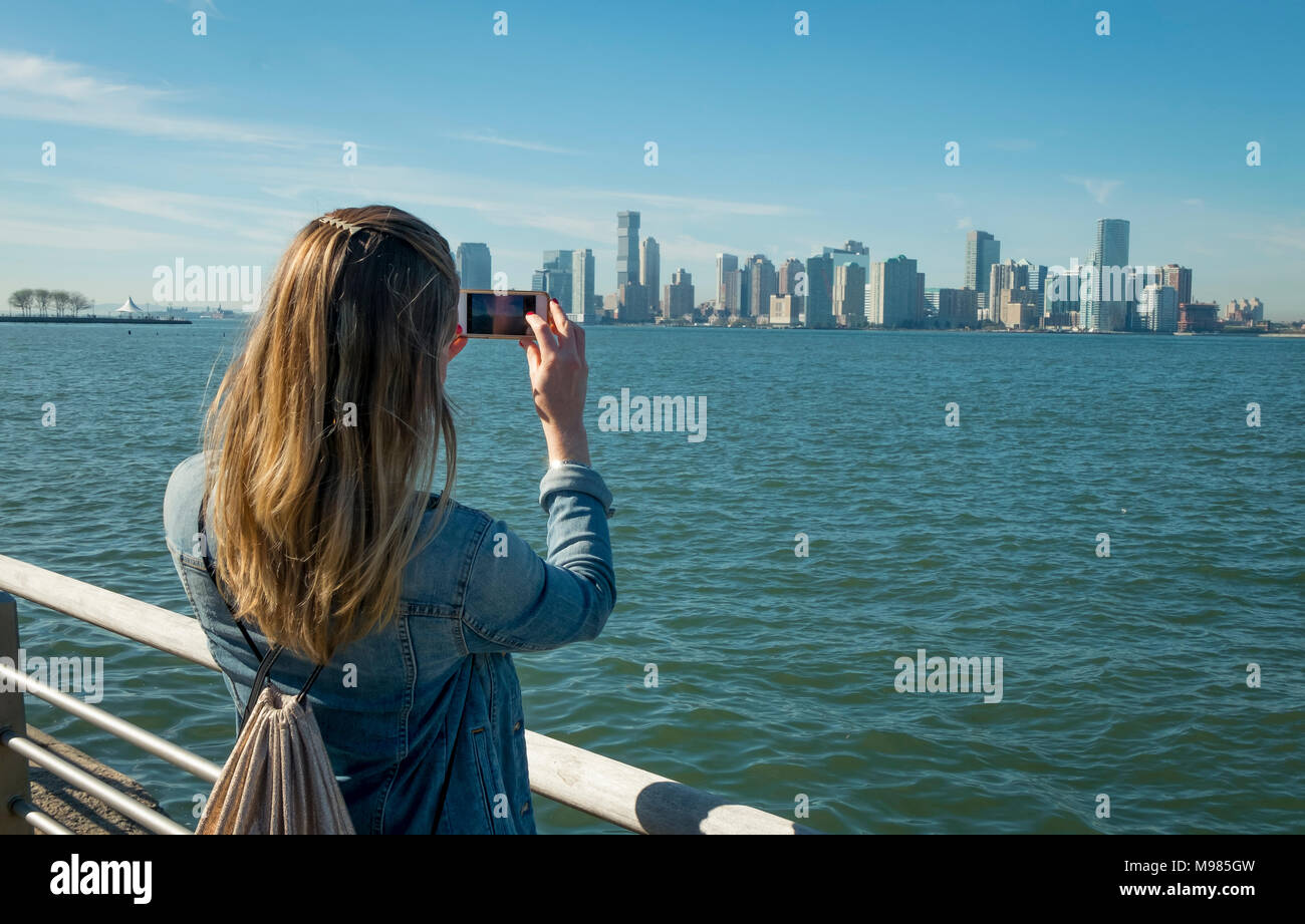 Stati Uniti d'America, New York, donna prendendo cellulare foto del New Jersey skyline Foto Stock