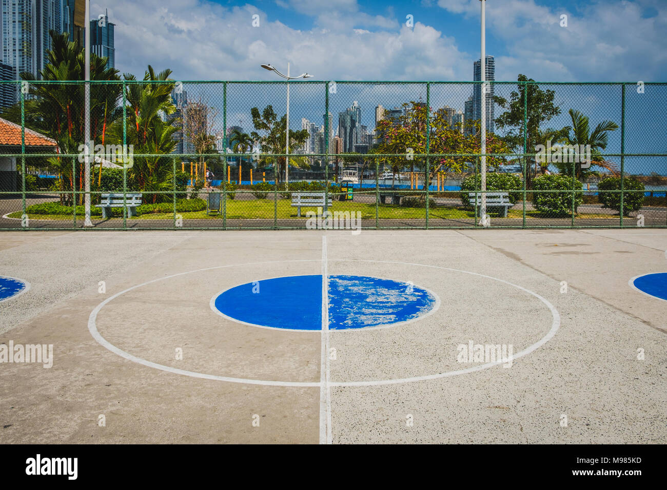 Campo da pallacanestro cerchio centrale con parco e sullo skyline di sfondo - Foto Stock