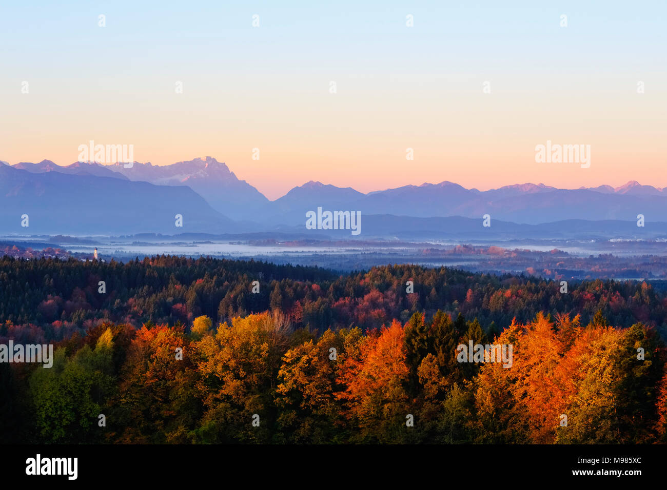 Kirchturm von Königsdorf, Zugspitze und Ammergauer Alpen im Sonnenaufgang, Ausblick von Peretshofener Höhe bei Dietramszell, Oberbayern, Alpenvorland, Foto Stock