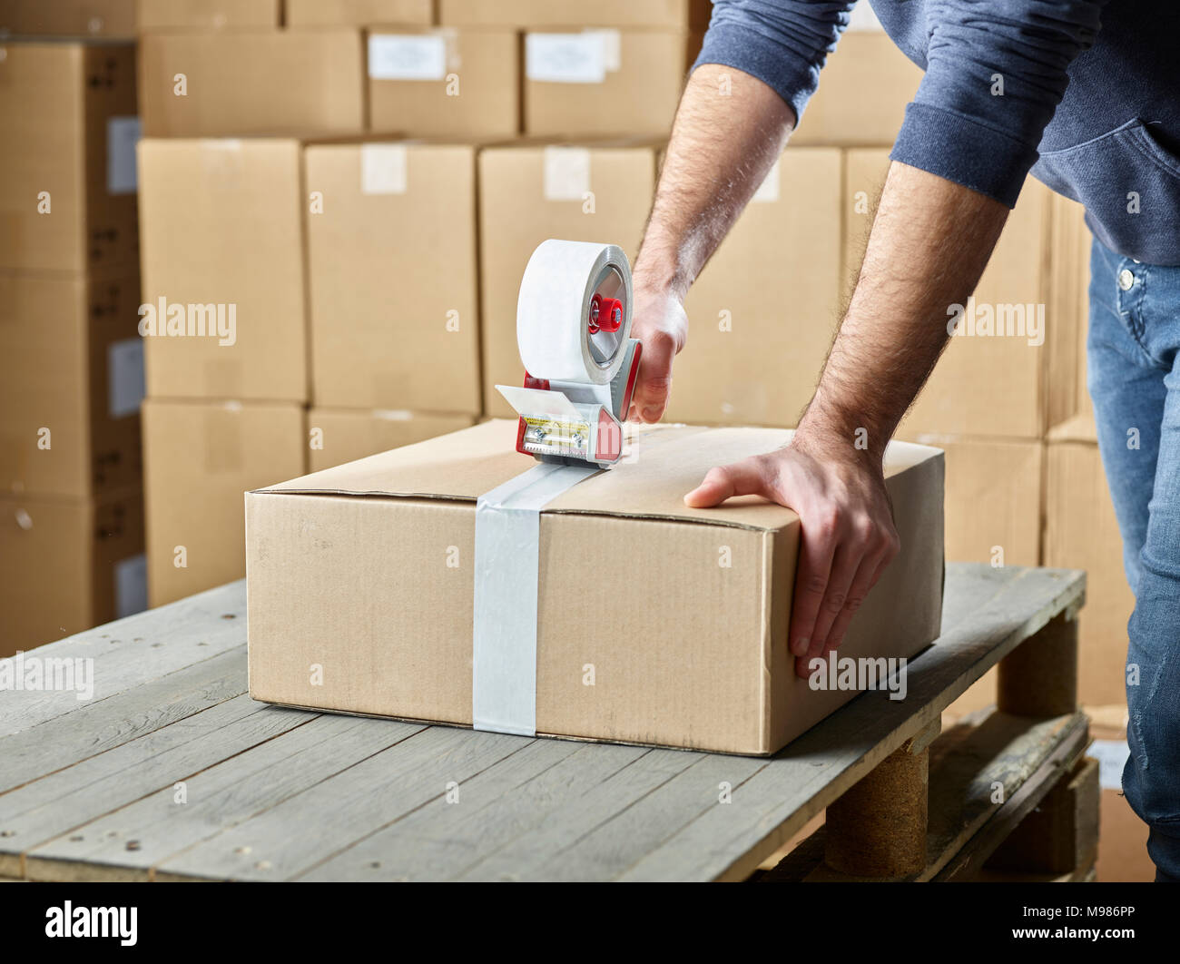 Lavoratore pacchetto di chiusura con nastro di imballaggio Foto Stock