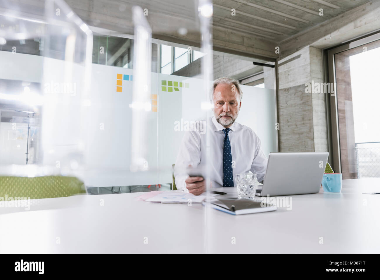 Imprenditore maturo lavorare alla scrivania in ufficio Foto Stock