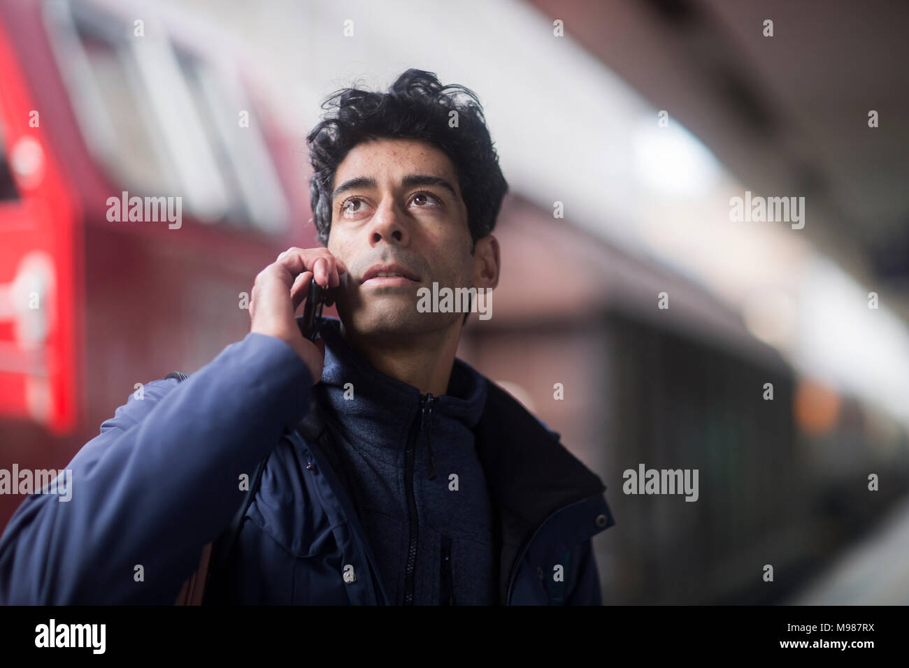 Ritratto di uomo al telefono in attesa sulla piattaforma Foto Stock