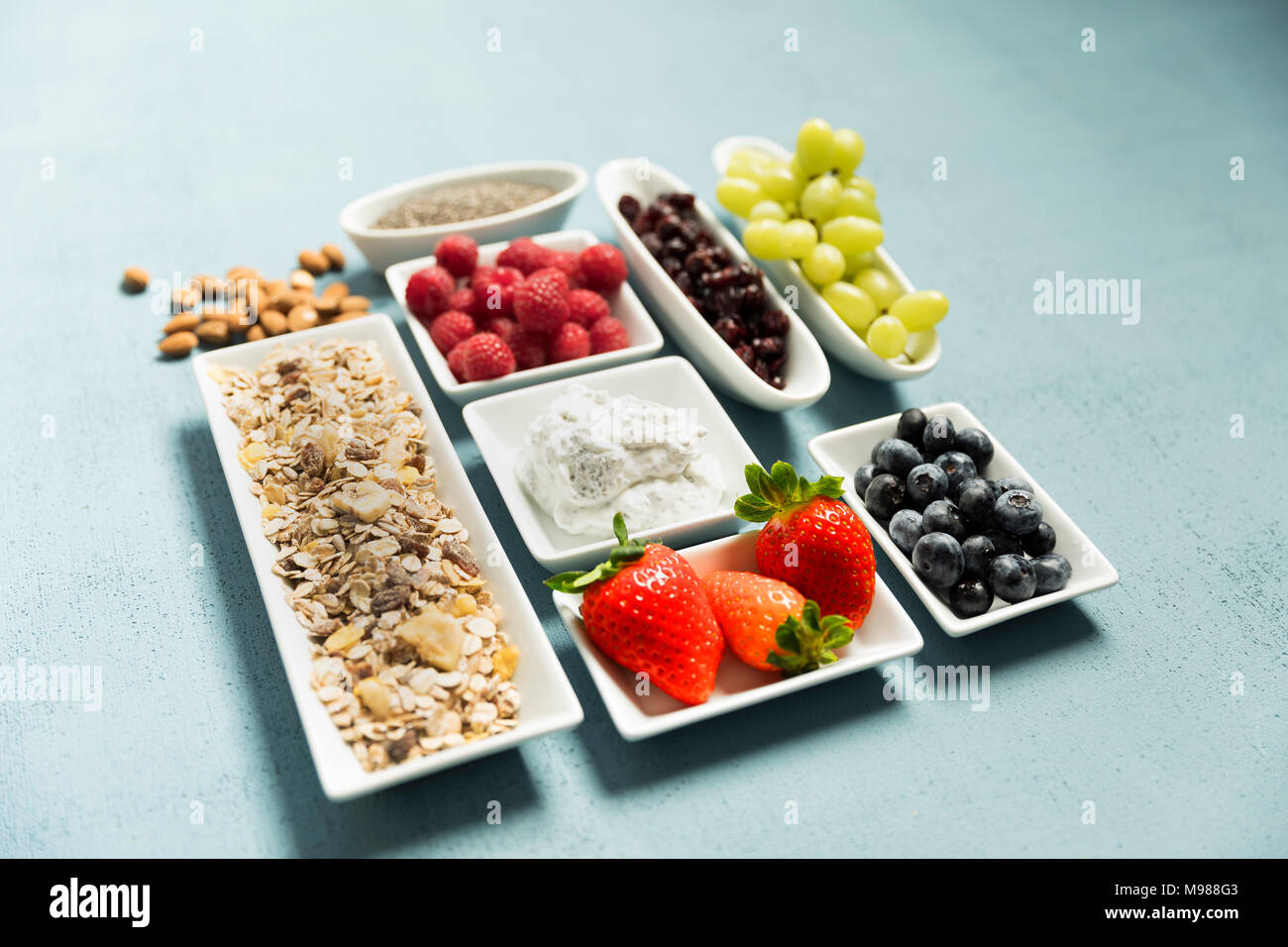 Ingredienti per il muesli, chia semi, latticini, Cranberries, uva, mirtilli, lamponi, fragole, mandorle Foto Stock