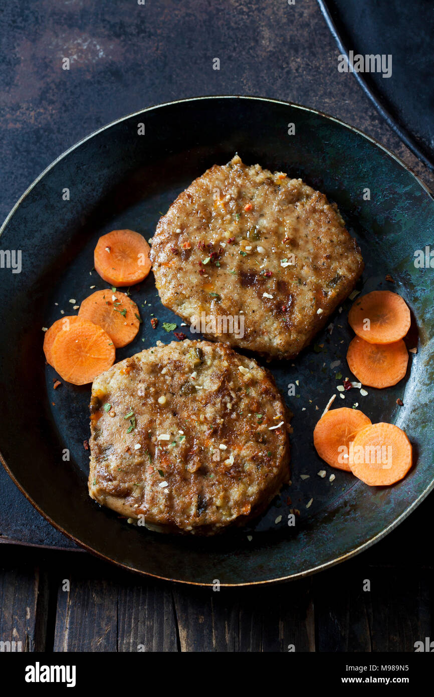 Hamburger Vegetariano e fette di carota in padella Foto Stock