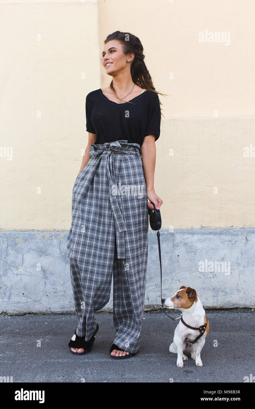 Donna sorridente a piedi un cane Jack Russell Foto Stock