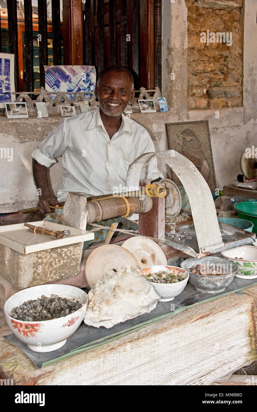 Un sorridenti maschile artigiano dello Sri Lanka lucidatura lavoratore gemma Pietre per gioielli utilizzando i metodi tradizionali presso il Museo Nazionale di Galle. Foto Stock