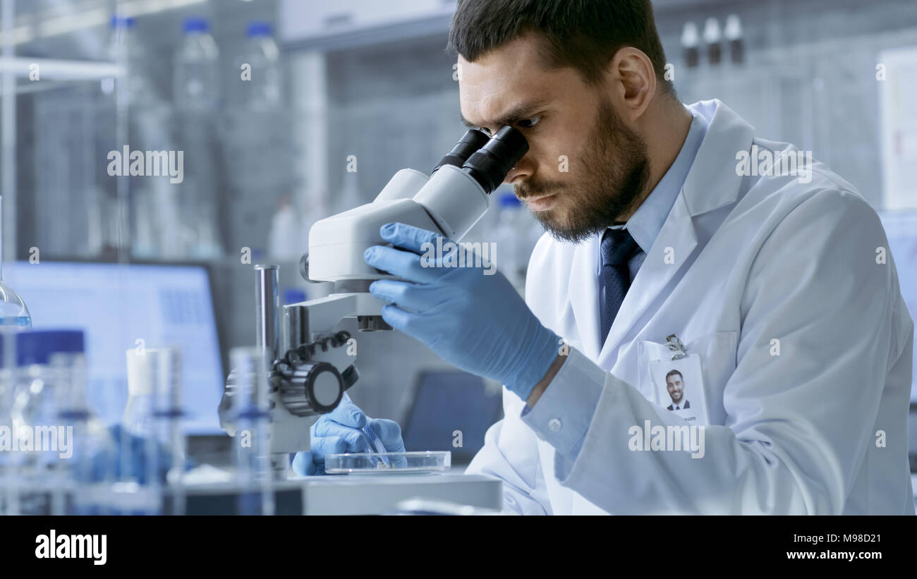 In un moderno laboratorio di ricerca capo scienziato guarda in un microscopio. Foto Stock